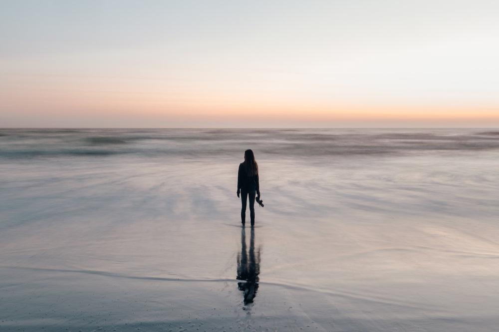 woman-wades-in-ocean-at-sunset